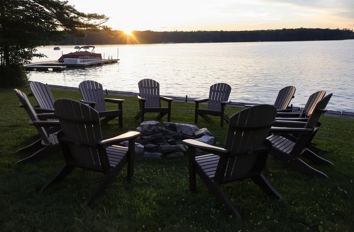 chairs around a campfire at lakeside
